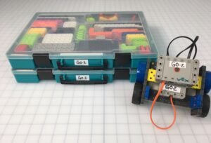 VEX Robotics GO kit boxes and a small GO robot on a classroom grid.