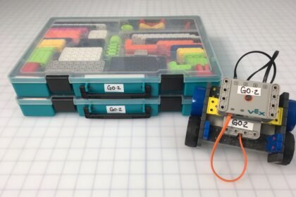 VEX Robotics GO kit boxes and a small GO robot on a classroom grid.