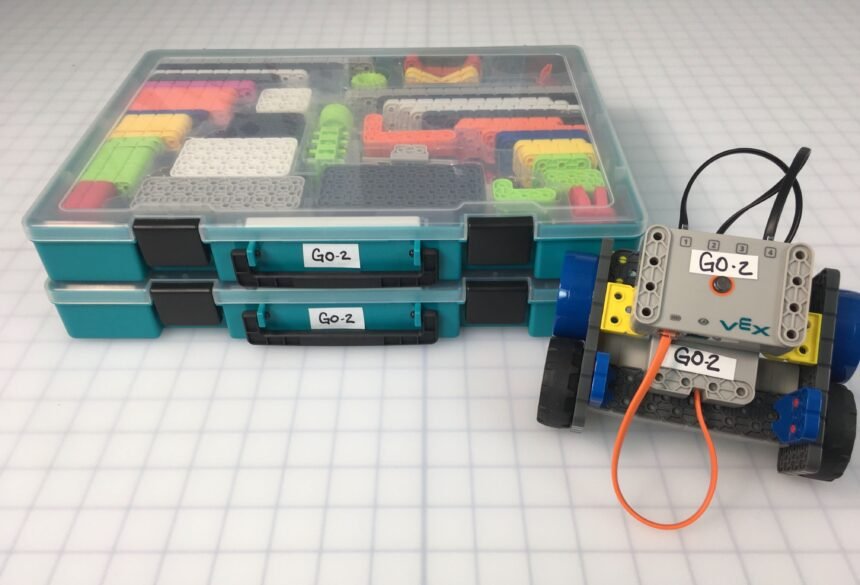 VEX Robotics GO kit boxes and a small GO robot on a classroom grid.